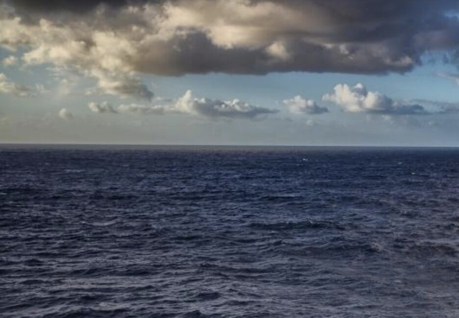 dark Pacific Ocean, with clouds above