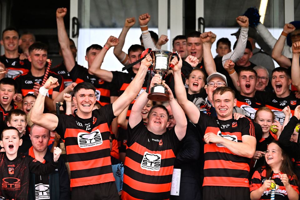 Ballygunner joint-captains Adam Hogan, left, and Mikey Mahony lift the cup with supporter Tom Mullane after their side's victory in the Waterford SHC final at Walsh Park. Photo: Piaras Ó Mídheach/Sportsfile