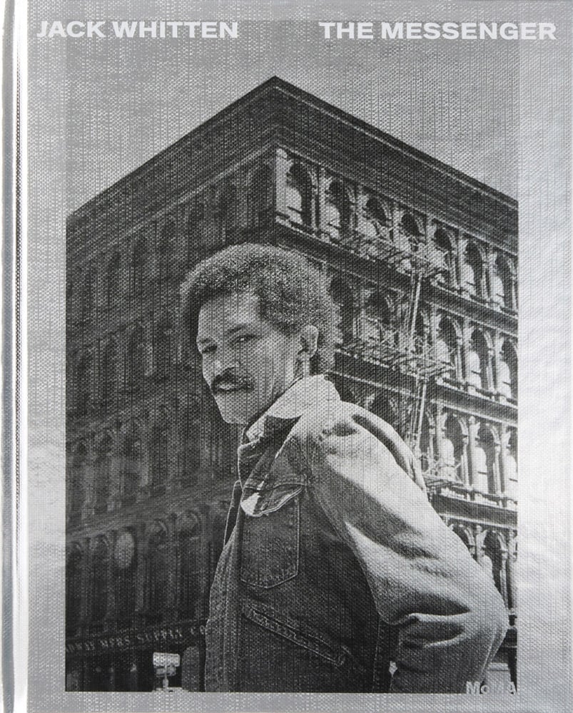 An image of the book cover for Jack Whitten: The Messenger, showing a black-and-white photograph of Jack Whitten standing before a cast-iron building with the title across the top.