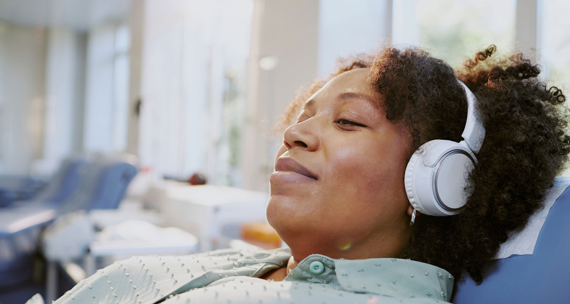 Woman listening to music while waiting for medical treatment.