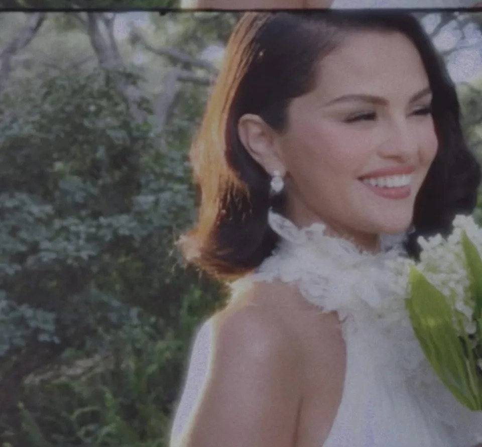 woman in a formal dress holding flowers outdoors