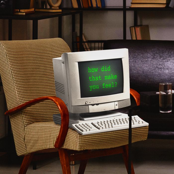 A old-school desktop computer sits on a brown checkered armchair in an office. Its screen reads 