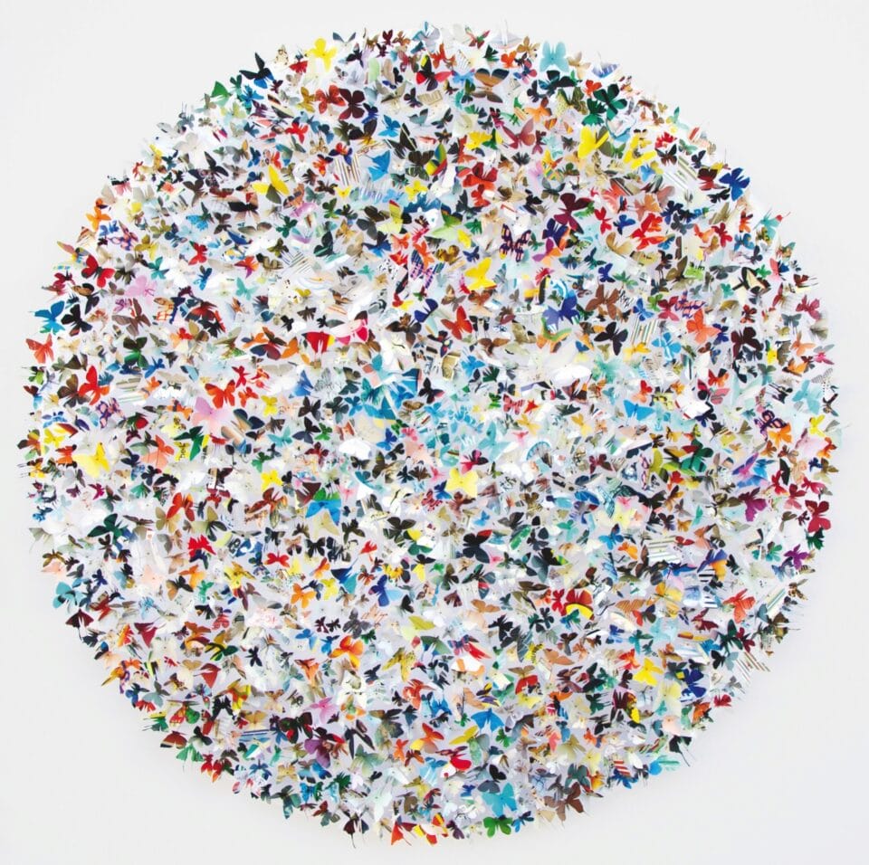 a circular composition of hundreds of colorful butterflies by artist Rebecca Coles