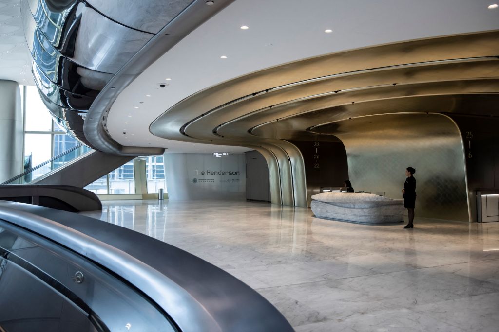 Staff are seen at the reception of The Henderson, a new skyscraper designed by Zaha Hadid Architects, where Christie's new auction house will be situated, is seen at the Central district of Hong Kong on July 25, 2024. Three of the world's top auction houses are racing to expand in Hong Kong, eager to woo young Asian buyers even as the global art market retreats from pandemic-era highs. In the span of two months, Sotheby's, Christie's and Bonhams will each see the culmination of years-long efforts to upgrade their regional headquarters in the southern Chinese city. (Photo by ISAAC LAWRENCE / AFP) / TO GO WITH: Hong Kong-China-economy-auction-art, FOCUS by Holmes CHAN (Photo by ISAAC LAWRENCE/AFP via Getty Images)