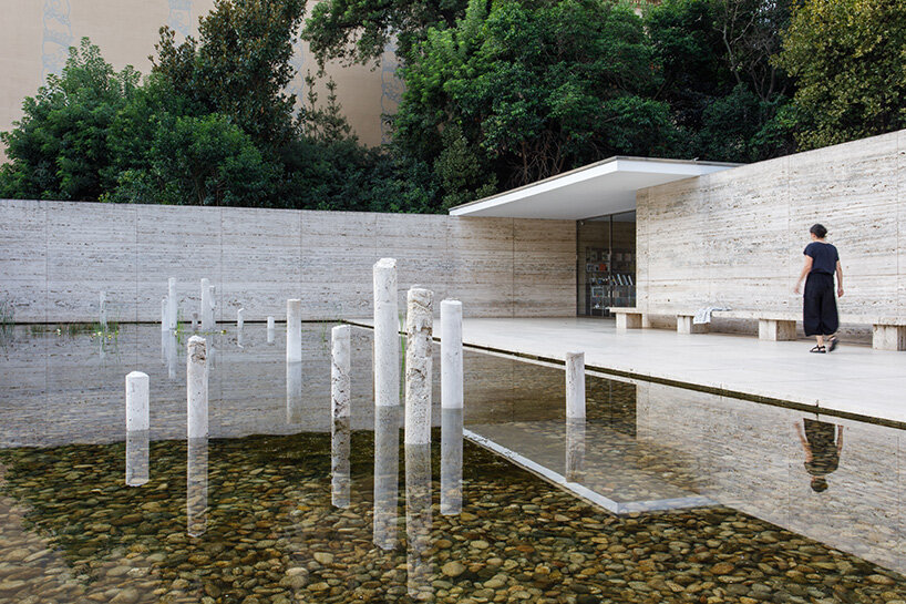 concrete sculptures surface from the pond of mies van der rohe's barcelona pavilion