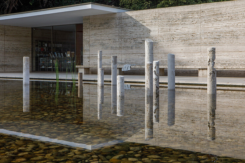 concrete sculptures surface from the pond of mies van der rohe's barcelona pavilion