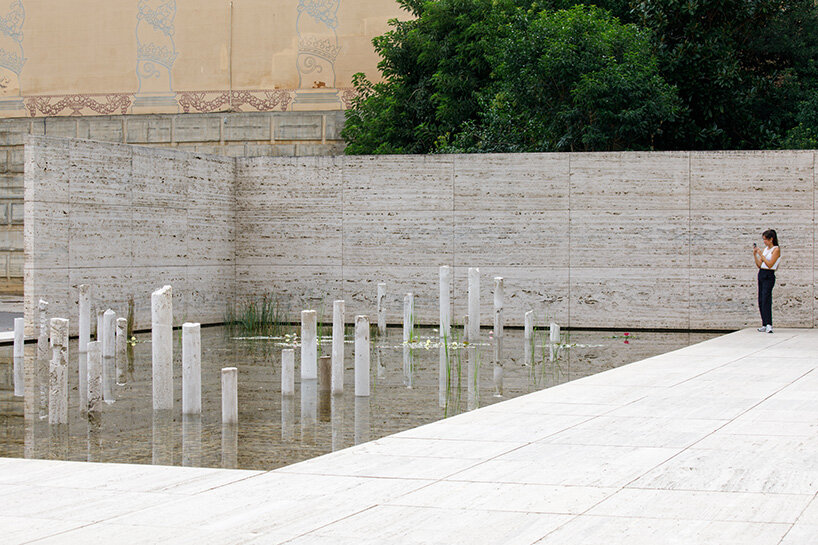concrete sculptures surface from the pond of mies van der rohe's barcelona pavilion