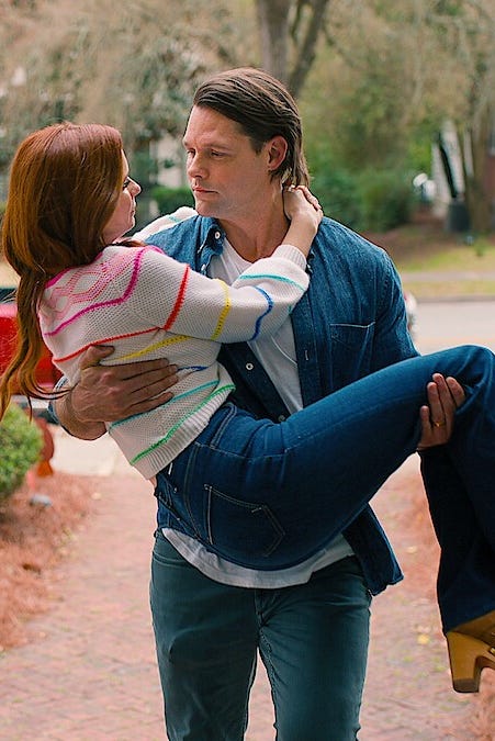 Man carrying a woman in his arms on a front walk they are looking in each other's eyes man carrying a woman in his arms on a front walk they are looking in each other's eyes