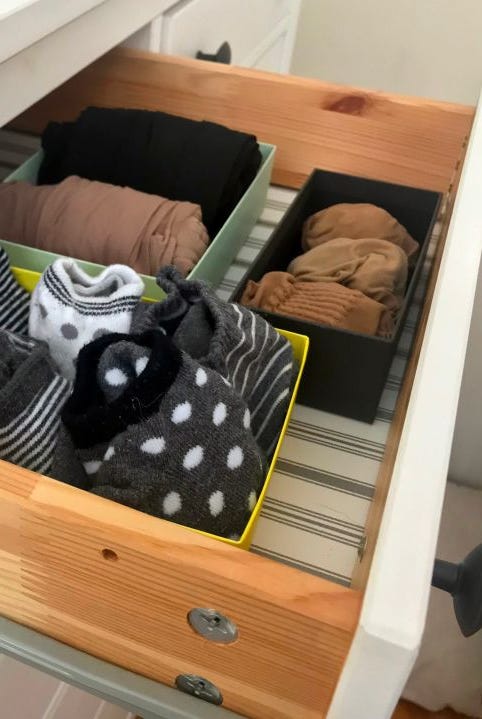 socks and tights are seen arranged in small boxes in a drawer lined with striped paper socks and tights are seen arranged in small boxes in a drawer lined with striped paper