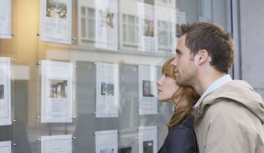 A couple look at properties in an estate agent window