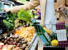 A woman grocery shopping with a basket.