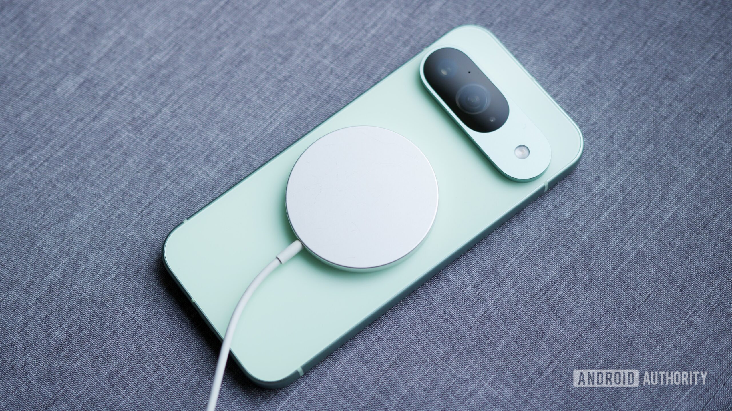 A Google Pixel 9 with a MagSafe charging puck on its back.