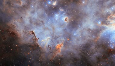 Stars in a star cluster shine brightly blue, with four-pointed diffraction spikes radiating from them. The center shows a small, crowded group of stars while a larger group is partially visible on the right side of the image. The nebula is mostly thick, smoky clouds of gas, lit up in blue tones by the stars. Clumps of dust hover before and around the stars; they are mostly dark but lit around their edges where the starlight erodes them.