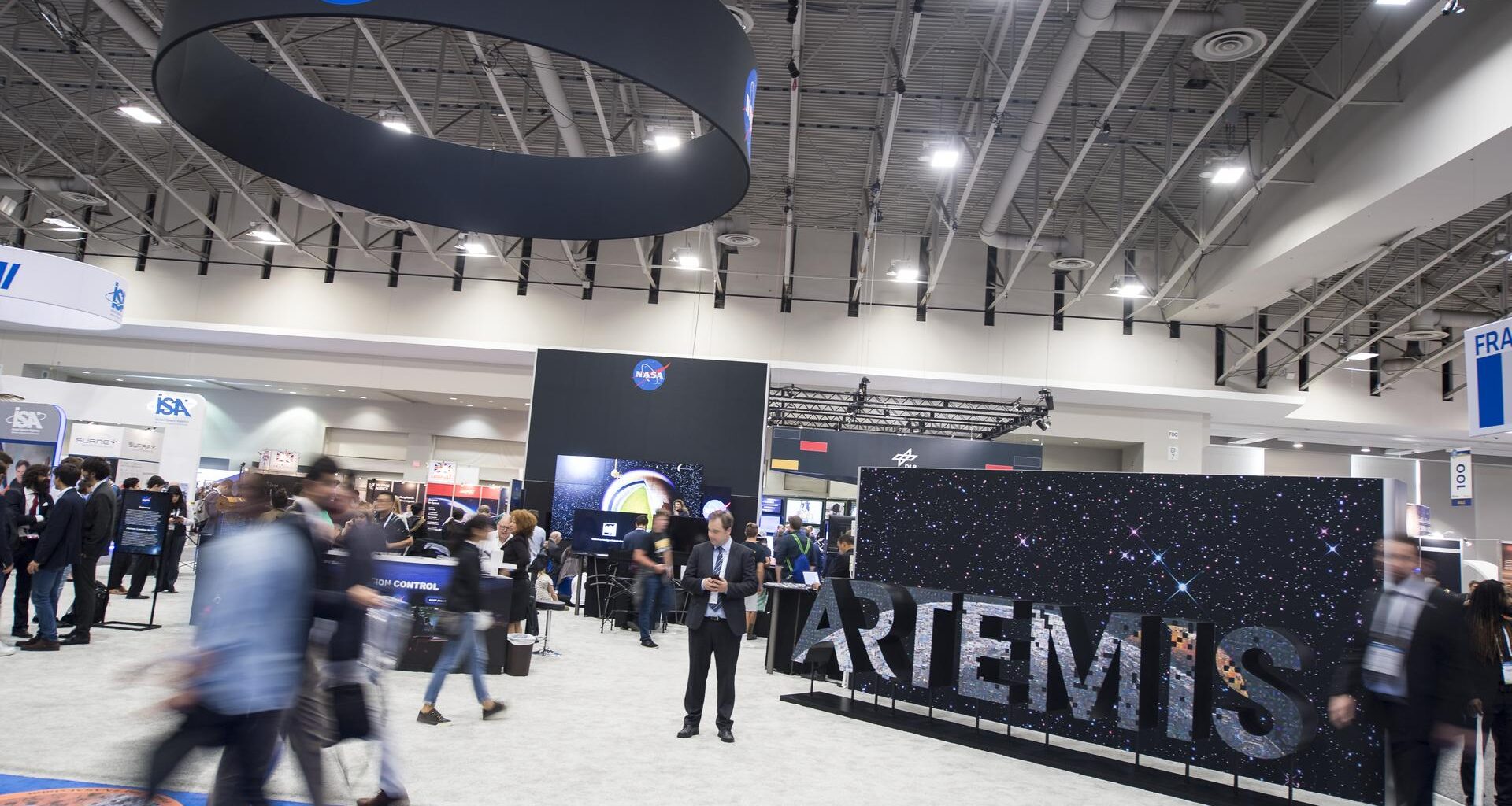 Attendees are seen by the NASA exhibit at the 70th International Astronautical Congress, Friday, Oct. 25, 2019, at the Walter E. Washington Convention Center in Washington.