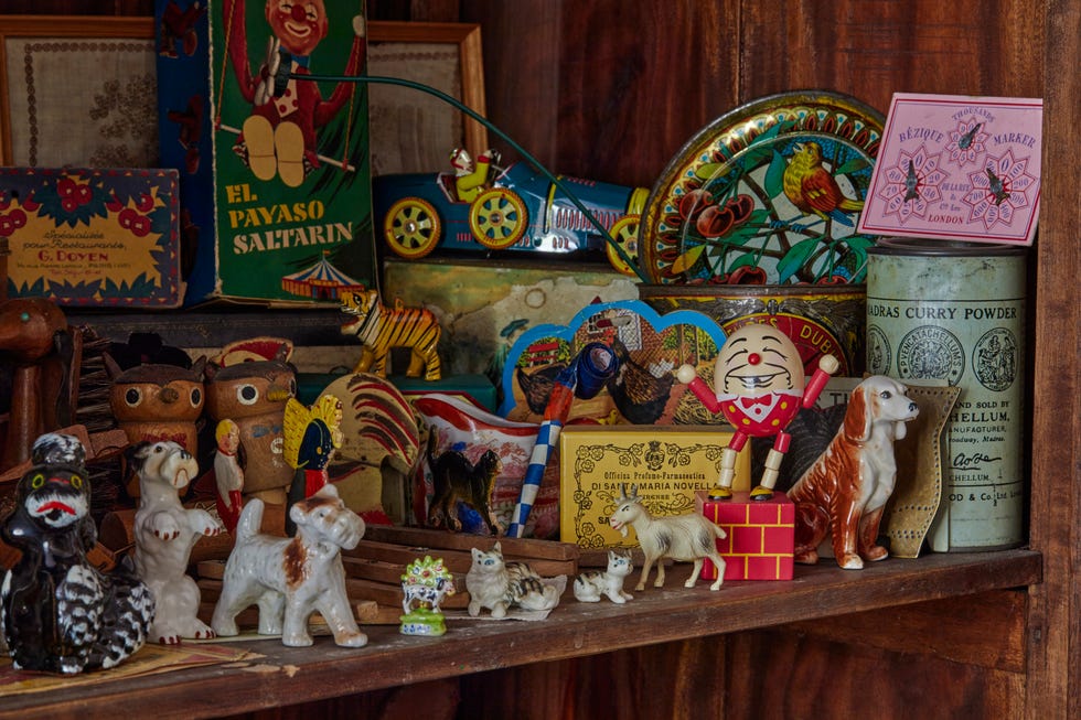 Vintage toy collection in Emily Sutton’s York terrace shelf in emily sutton’s york victorian terrace filled with vintage toys, ceramic dog figurines, humpty dumpty toy, and retro packaging