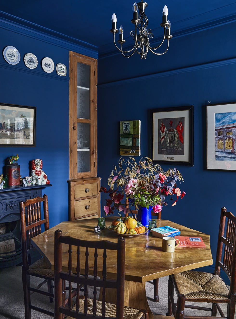 Dining room in Emily Sutton’s York Victorian terrace dining room painted in farrow & ball stiffkey blue with antique furniture and colourful textiles in emily sutton’s york home