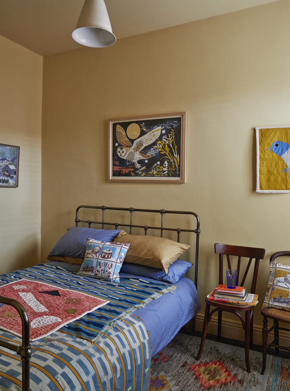 Emily Sutton’s spare bedroom with Mark Hearld print spare bedroom featuring mark hearld’s owl flight lithograph, st jude’s fabric cushion, and collected vintage furniture