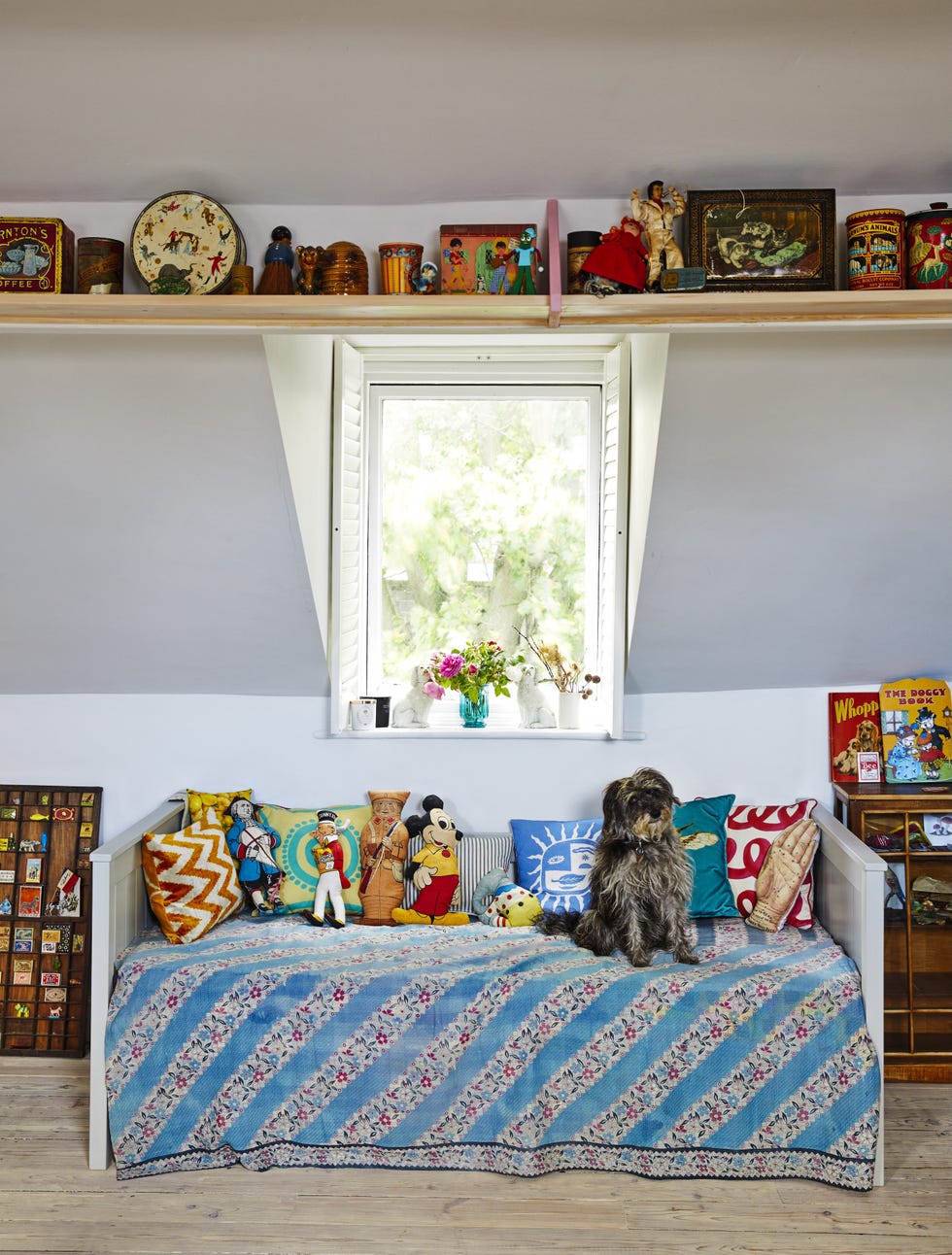Emily Sutton’s dog Mouse resting in the studio miniature schnoodle mouse resting on an antique french blanket on the daybed in emily sutton’s studio