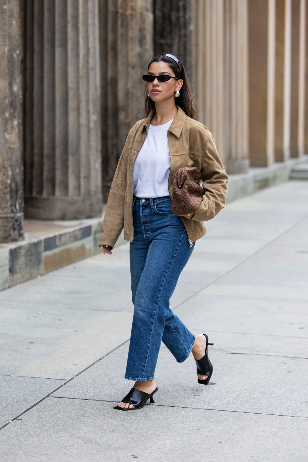 berlin, germany july 01: bella emar wears levi’s blue denim jeans, white cos t shirt, brown massimo dutti jacket, black hm heels, mango sunglasses during the berlin fashion week ss25 on july 01, 2024 in berlin, germany. (photo by christian vierig/getty images)