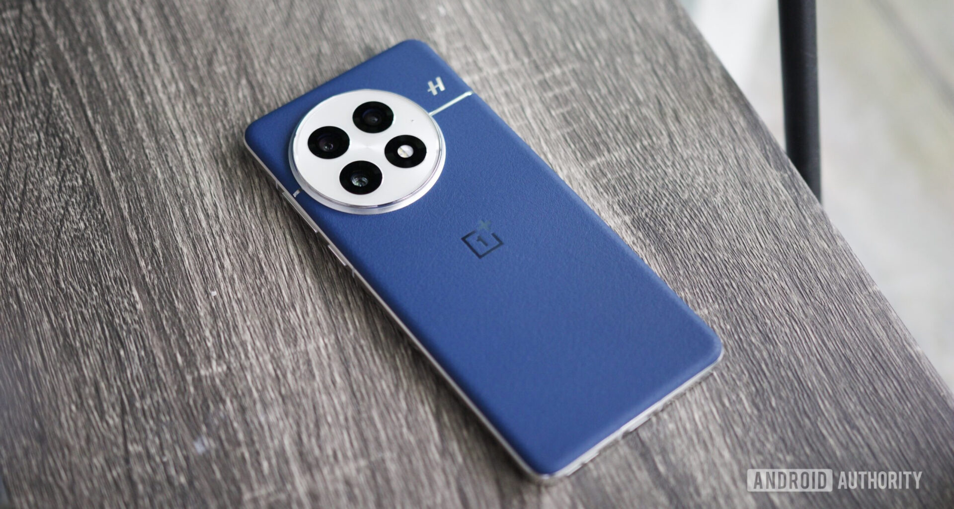 The blue leather OnePlus 13 lying on a shelf.