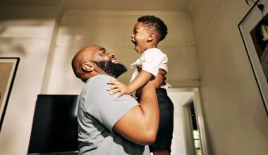 A non-custodial father celebrates his new job by lifting his toddler into the air of a sun-dappled room.