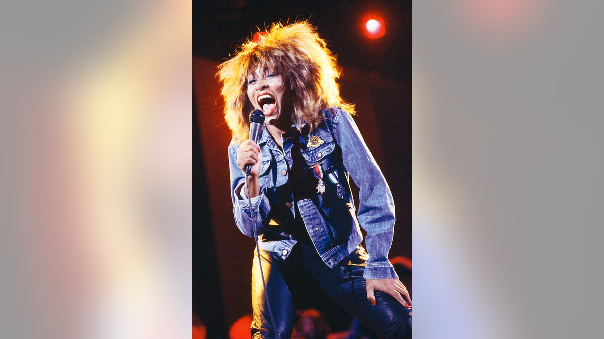 Tina Turner on stage singing.