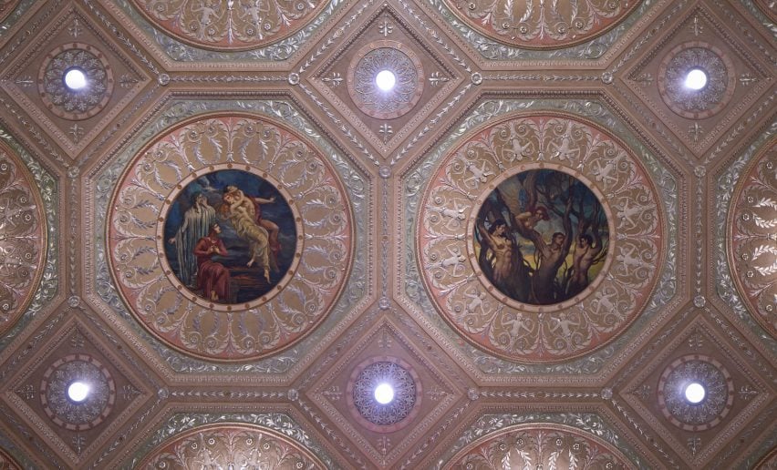 Looking up at an ornate ceiling with silver leaf details