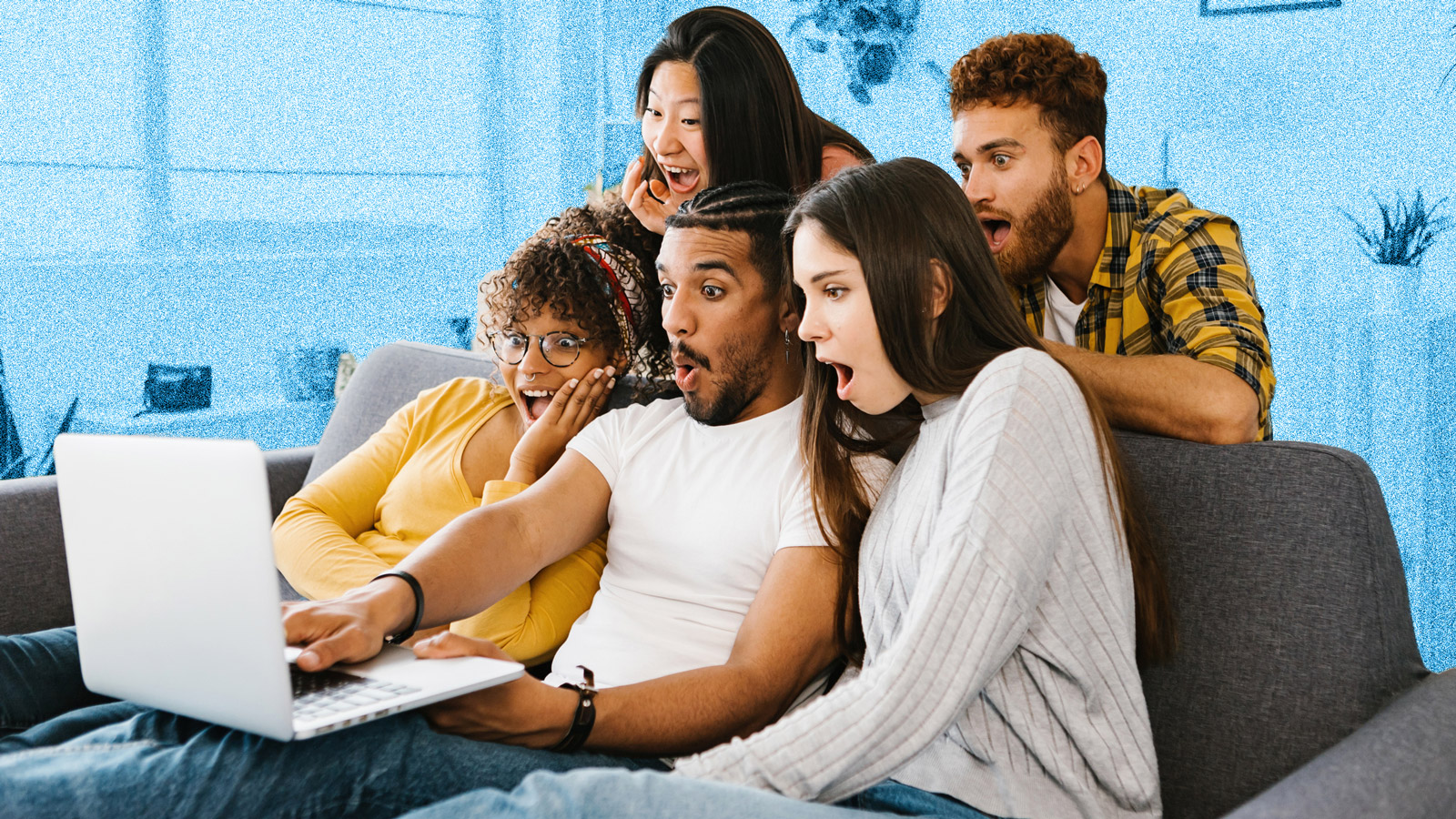 A group of young people sitting on a sofa around a laptop screen, all looking shocked and surprised.