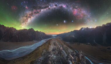 a dramatic wide-angle photo of a rocky landscape with aurora borealis and the Milky Way above