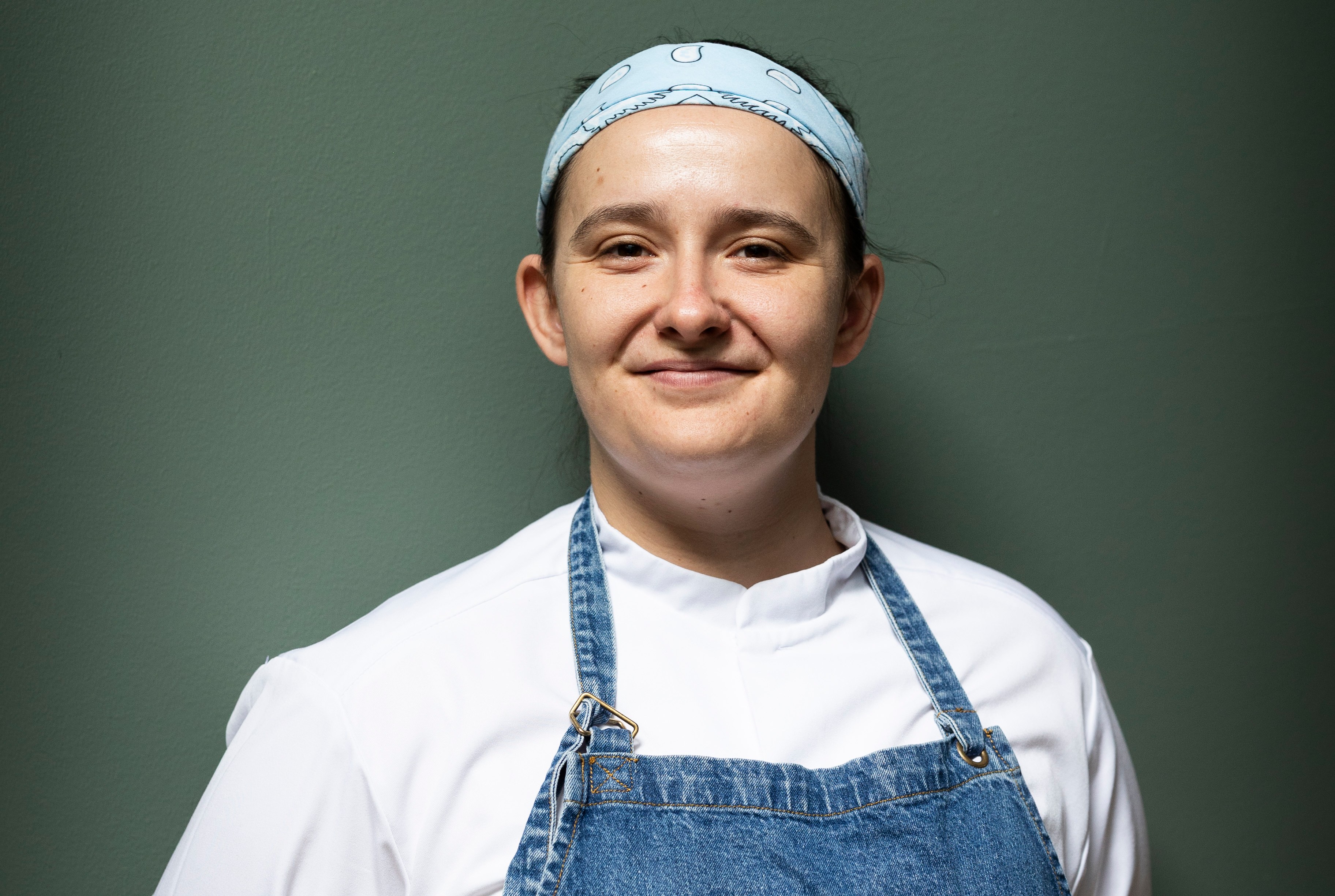 Aishling Moore, chef at Goldie in Cork City, wearing a white chef coat and a denim apron.