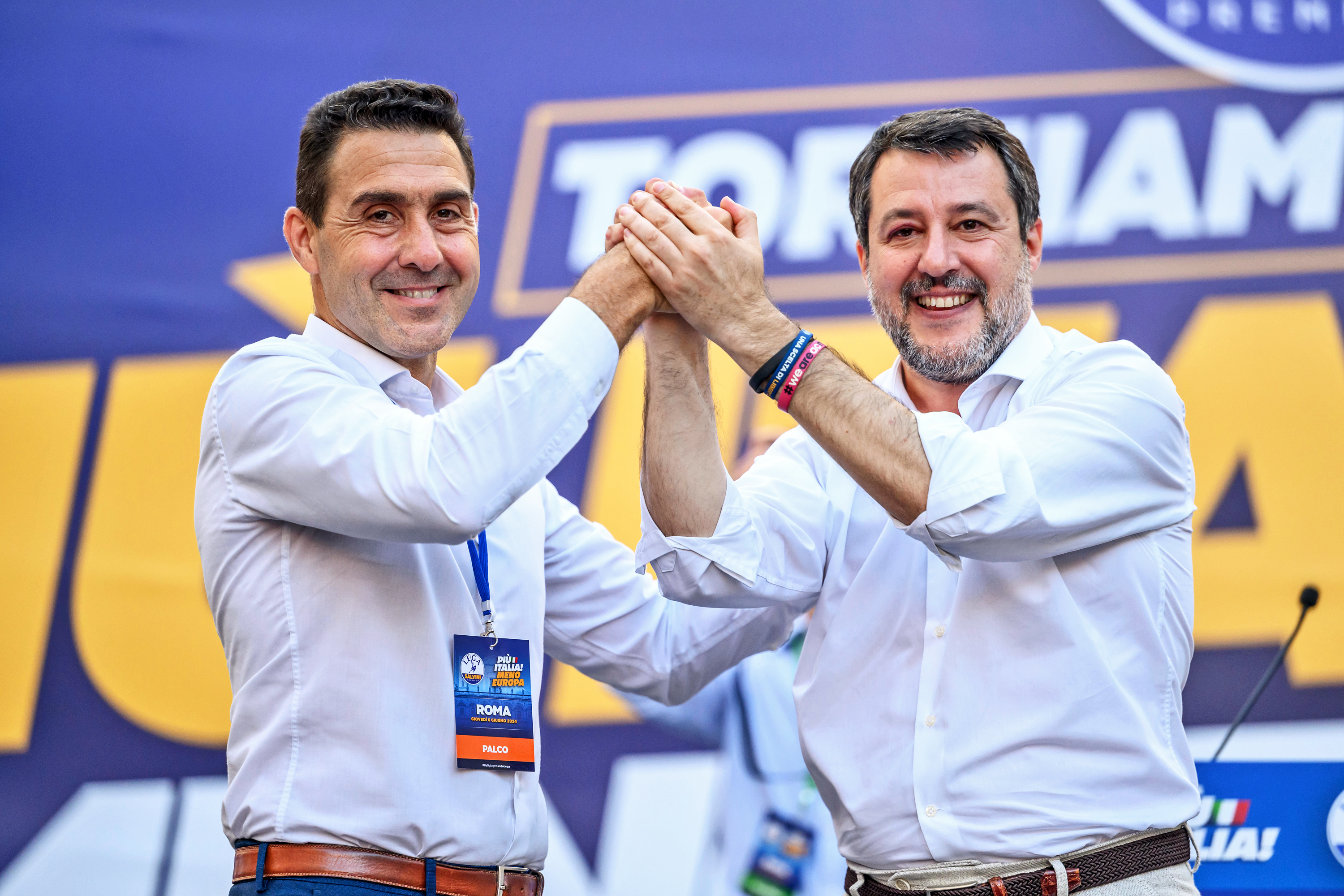 Roberto Vannacci and Matteo Salvini clasp hands at a Lega party meeting in Rome.