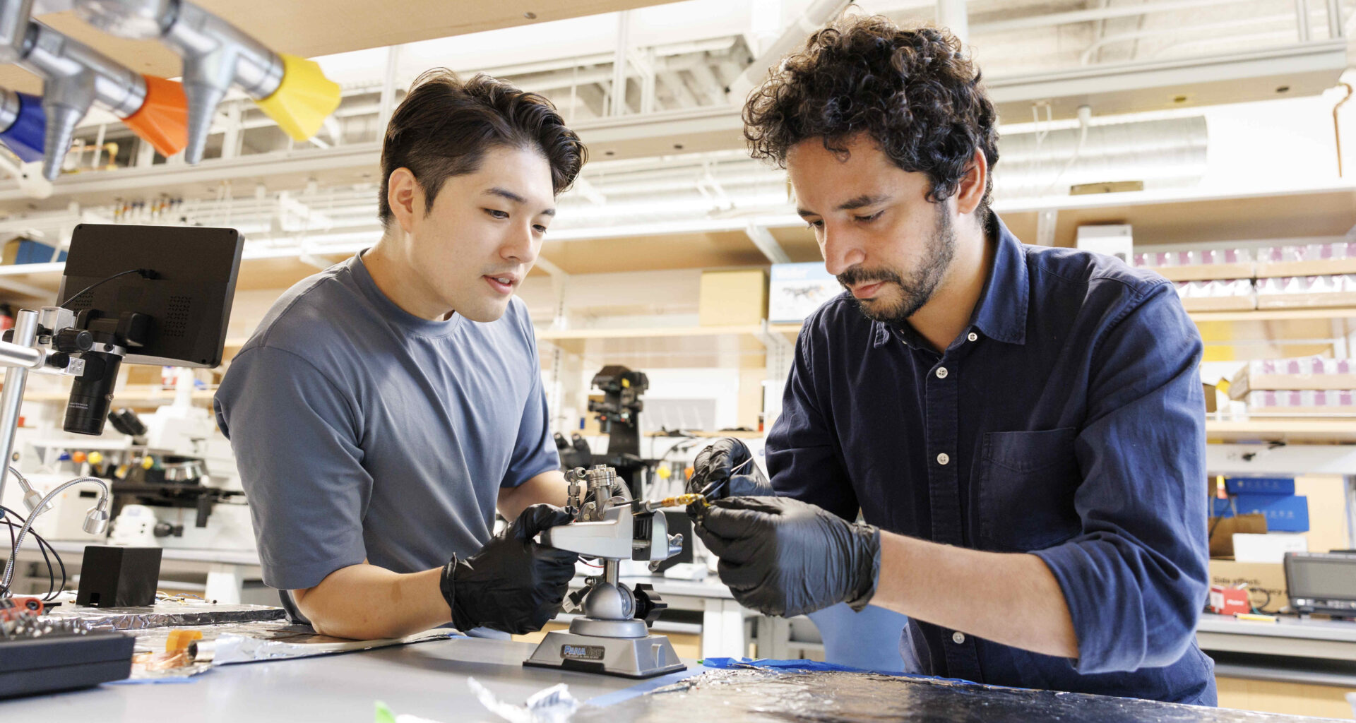 Suk Hyun Sung (left) and Ismail El Baggari working together on an electron microscope specimen holder.