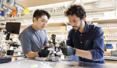 Suk Hyun Sung (left) and Ismail El Baggari working together on an electron microscope specimen holder.