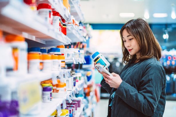 Woman reading medication in pharmacy