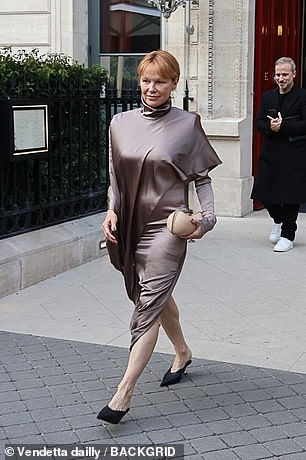 She paired her frock with black pointed-toe heels and carries a round, champagne-colored clutch.