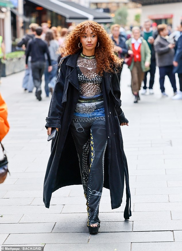 Leigh-Anne added to her 70s-inspired look with chunky black platform heels and a long blue trench coat
