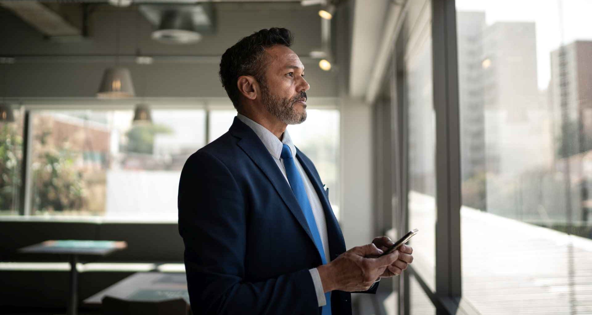 Serious businessman looking through the window.