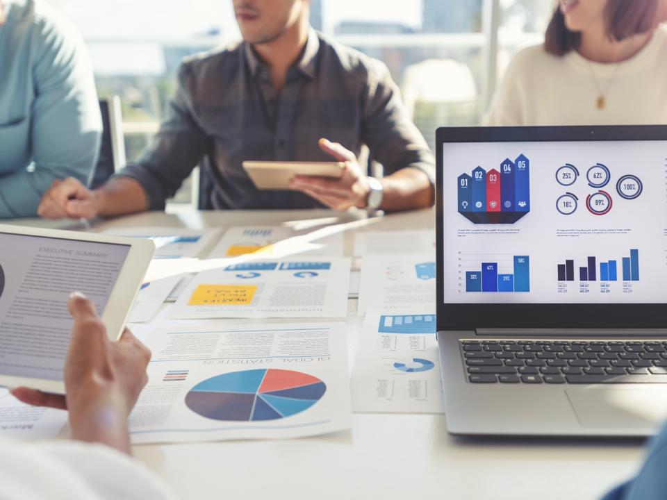 Team discussing market strategy and reviewing infographics