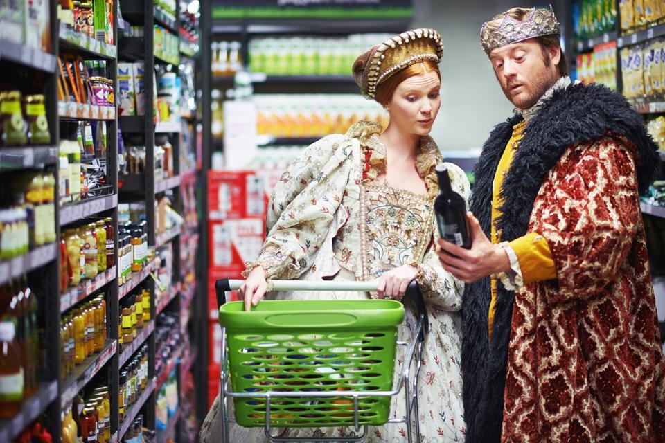 A couple dressed as a king and queen shop in the supermarket. 