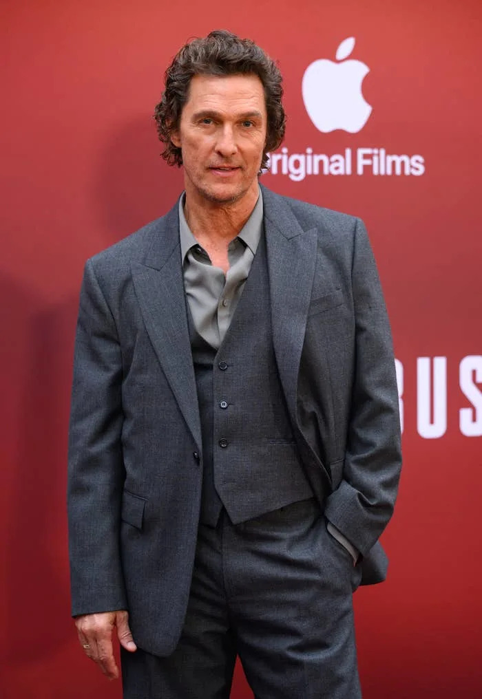 Person in a three-piece suit on a red carpet