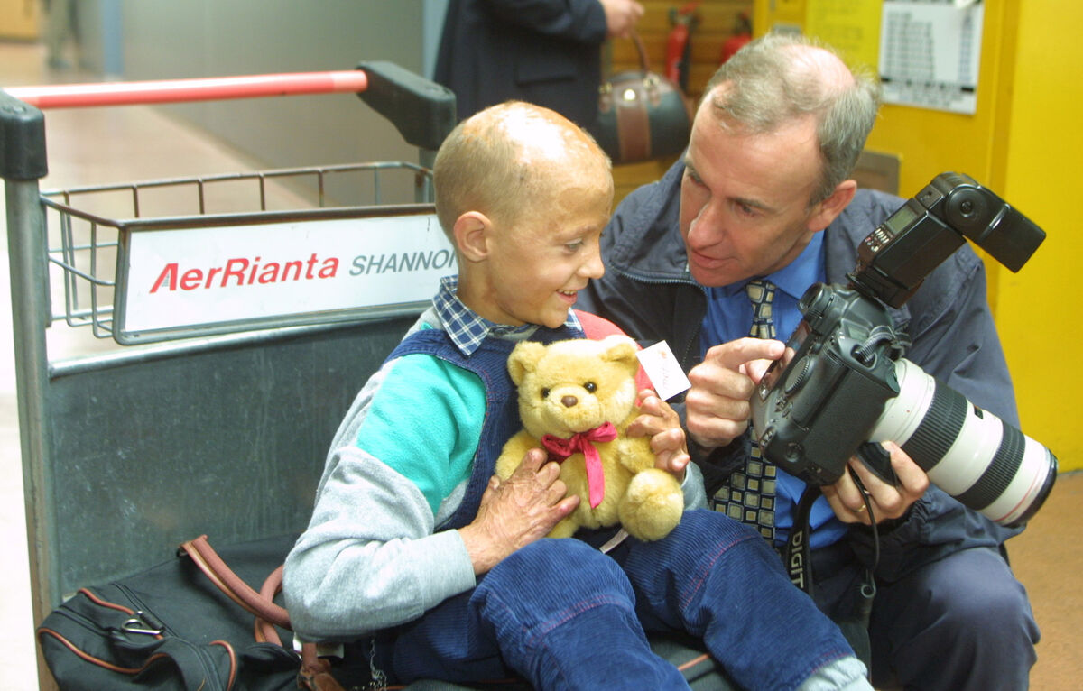 Irish Examiner photographer Kieran Clancy shows Nikolai Kutayev aged 6 from Belarus the pictures he has taken on his digital camera at Shannon Airport after Nikolai arrived with the Chernobyl Childrens Project. Picture James Horan/Press 22