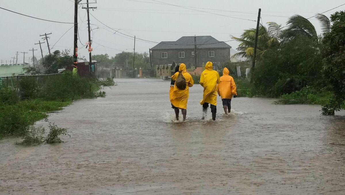People walk along a road during the passing of Hurricane Melissa in Rocky Point, Jamaica, Tuesday, Oct. 28, 2025. (AP Photo/Matias Delacroix)