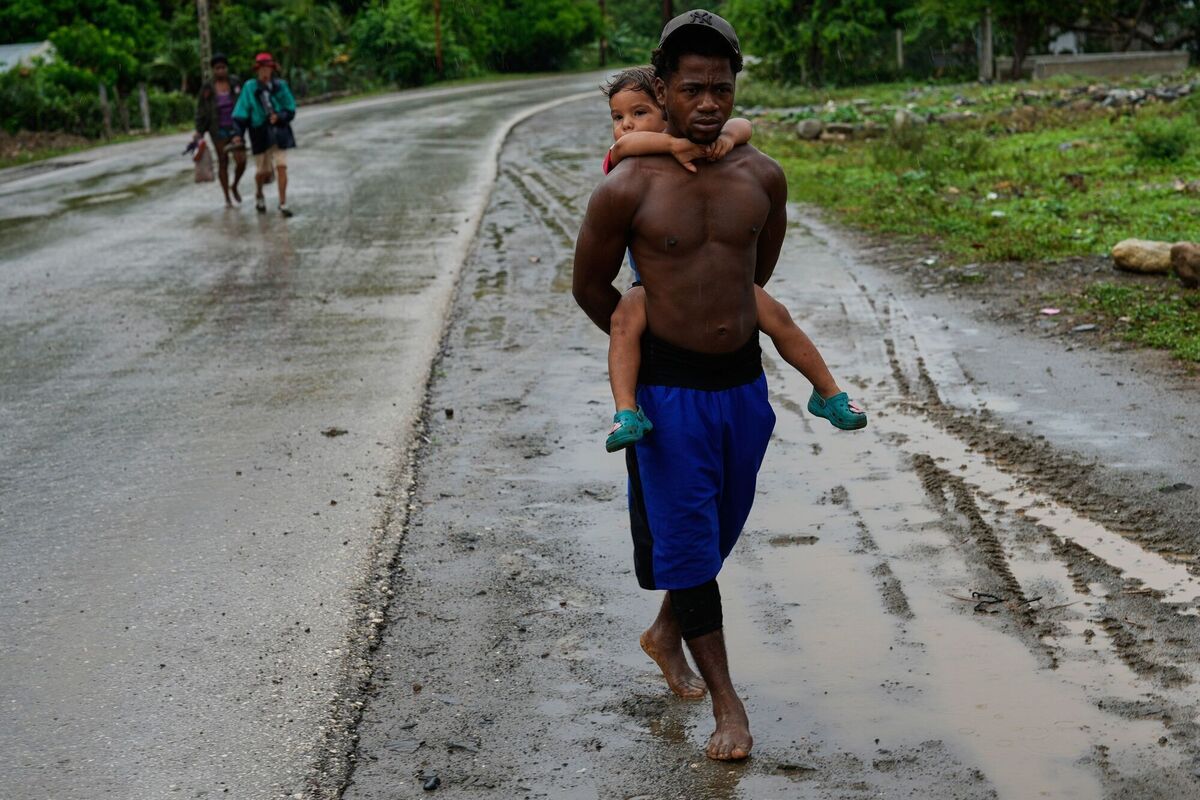 People evacuate before the the arrival of Hurricane Melissa in Canizo, a community in Santiago de Cuba, Tuesday, Oct. 28, 2025. (AP Photo/Ramón Espinosa)