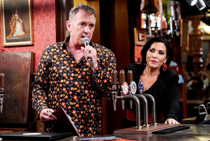 Alfie speaking into a microphone with Kat next to him ion EastEnders