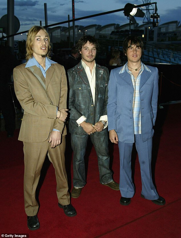 Johns (left) is pictured with his Silverchair bandmates Chris Joannou (centre) and Ben Gillies (right) in October 2002