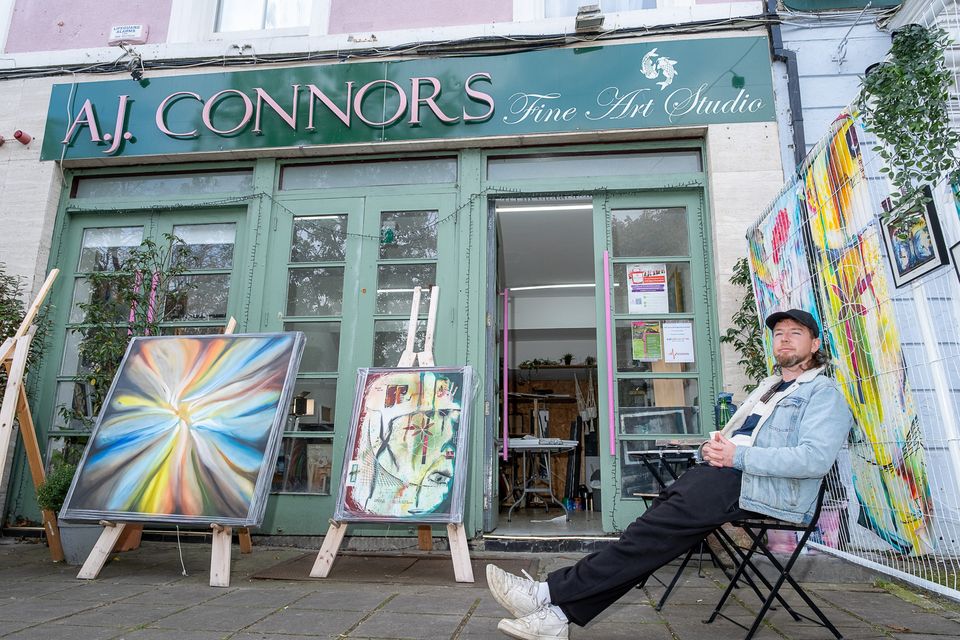 Artist Adam J Connors with some of his work, outside his studio in Bray.