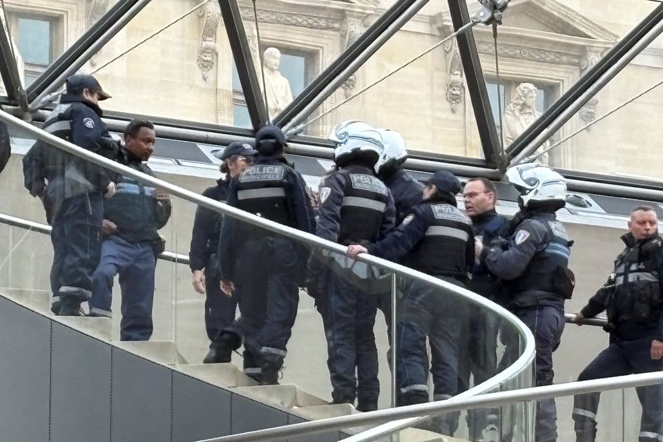 Police gather on the Louvre Pyramid spiral staircase, after the theft of Napoleon collection jewellery pieces at the museum. Photo: Reuters