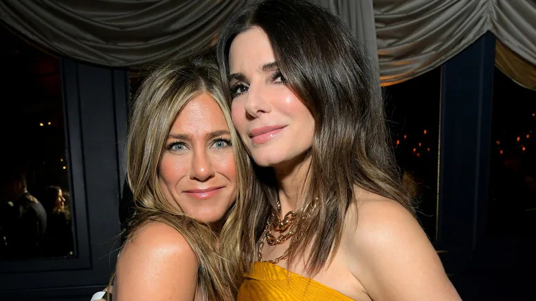 Sandra Bullock and Jennifer Aniston smiling at event