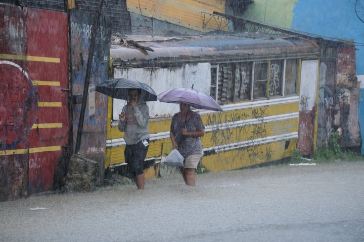 People wade through a street flooded by rains caused by Tropical Storm Melissa in Santo Domingo, Dominican Republic, Friday, Oct. 24, 2025. (AP Photo/Ricardo Hernandez)
