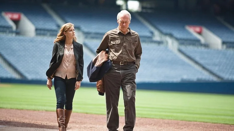 Mickey (Amy Adams) and Gus Lobel (Clint Eastwood) walk together on a baseball field in Trouble with the Curve